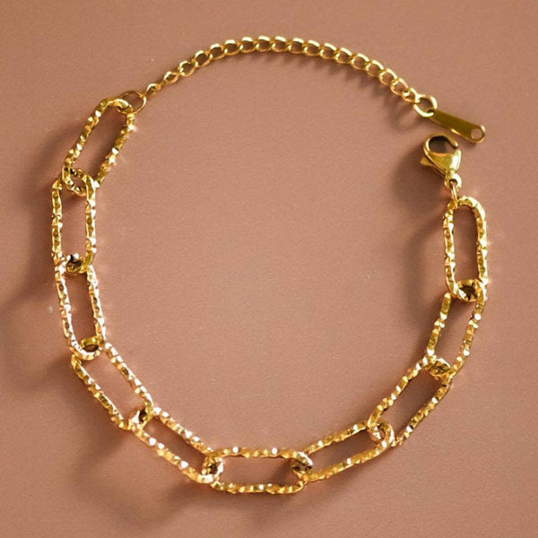 Gold chain bracelet on a brown background