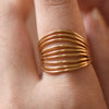 Gold ring with a ribbed design on a person's finger