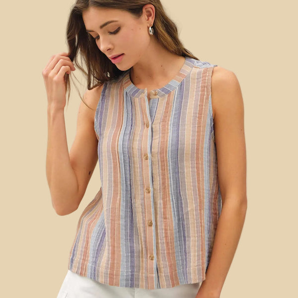 Woman wearing a sleeveless striped shirt against a beige background