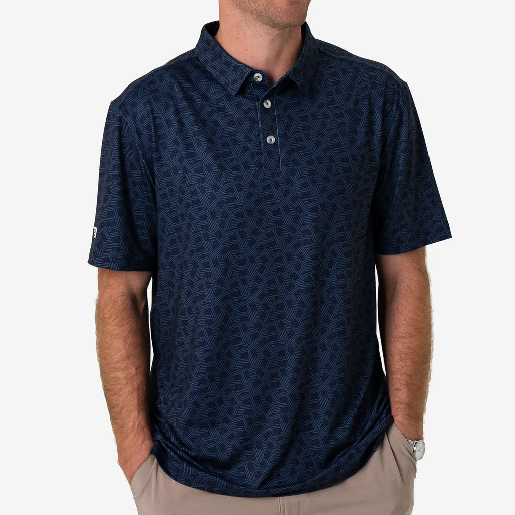 Man wearing a navy patterned polo shirt on a white background
