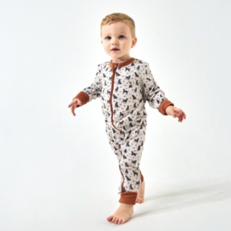 Baby in a zip up onesie with ducks and dogs on the print