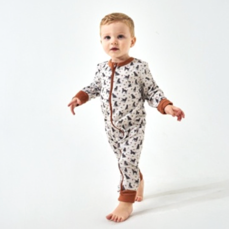 Baby in a zip up onesie with ducks and dogs on the print