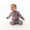 Baby wearing a patterned onesie on a white background