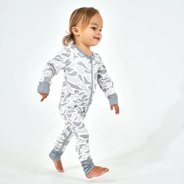 Child wearing a gray and white camouflage onesie on a white background