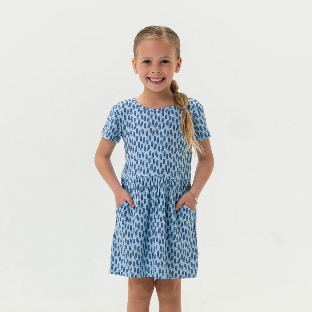 Young girl wearing a blue patterned dress on a white background