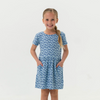 Young girl wearing a blue patterned dress on a white background