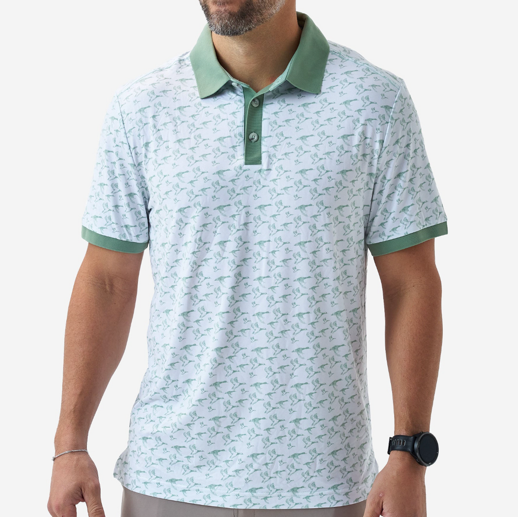Man wearing a light green patterned polo shirt with green accents on a white background