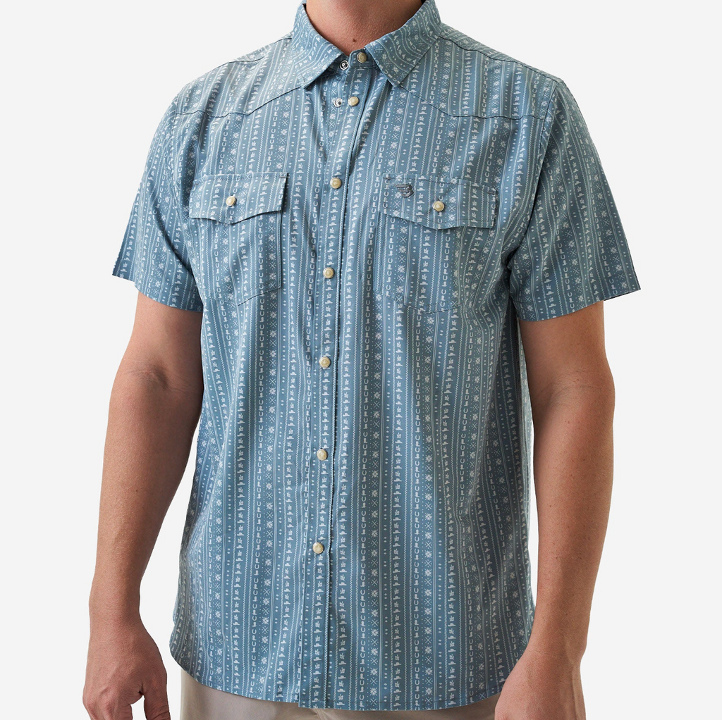 Blue patterned short-sleeve shirt worn by a person on a white background