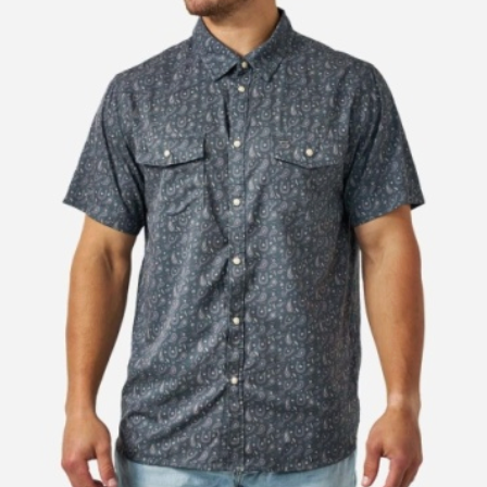 A man wearing a short-sleeve button-up shirt with a dark blue and gray paisley pattern, paired with light blue jeans, shown against a plain white background.