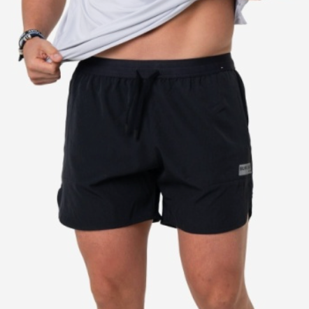 Man wearing black training shorts on a neutral background