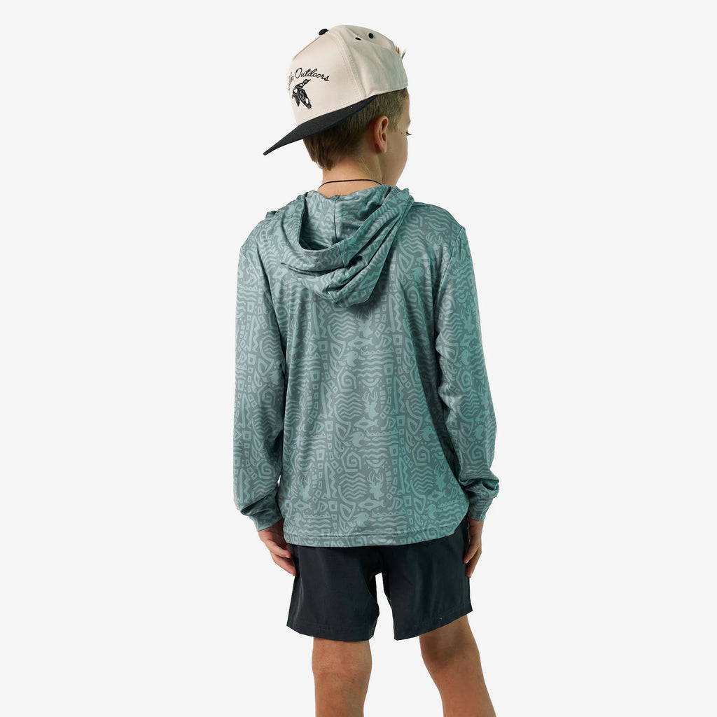 Person wearing a teal hoodie and black shorts with a beige cap on a white background