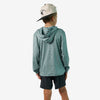 Person wearing a teal hoodie and black shorts with a beige cap on a white background