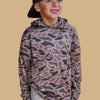Child wearing a camouflage hoodie on a beige background