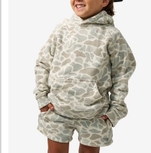 A young boy wearing a camo sweatshirt against a white background