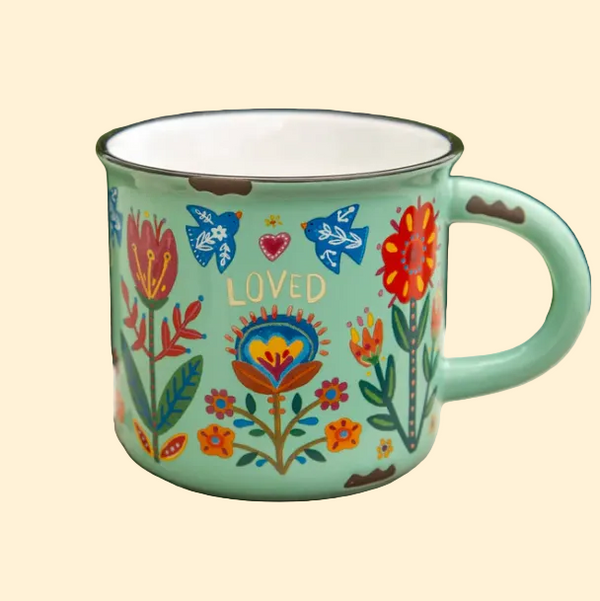 Decorative mug with floral patterns and the word 'LOVED' 