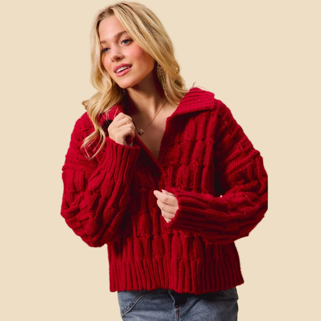 Woman wearing a red knitted cardigan against a beige background