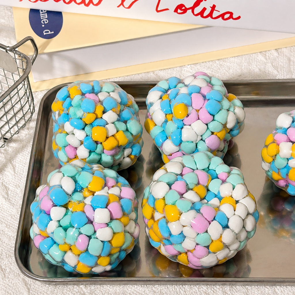Four colorful crunchy squishy balls with pastel blue, pink, yellow, and white.