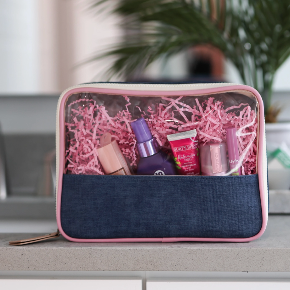 Cosmetic bag with pink interior filled with beauty products on a surface.