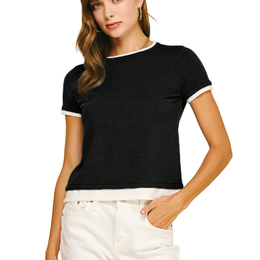 Woman wearing a black short-sleeve top with white trim on a beige background