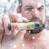 Person holding a Duke Cannon lip balm in a snowy outdoor setting