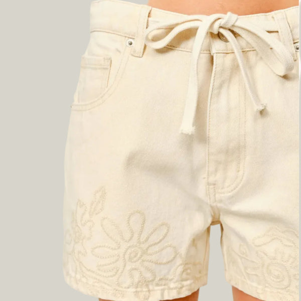 Beige shorts with floral embroidery on a plain background