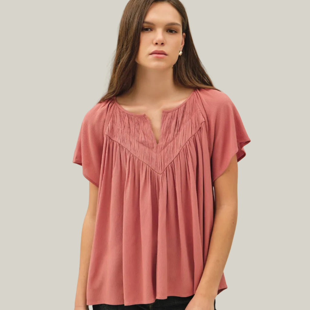 Woman wearing a pink blouse against a white background