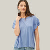 Woman wearing a light blue top with ruffled sleeves against a plain background