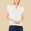 White blouse with ruffled details worn by a person on a white background