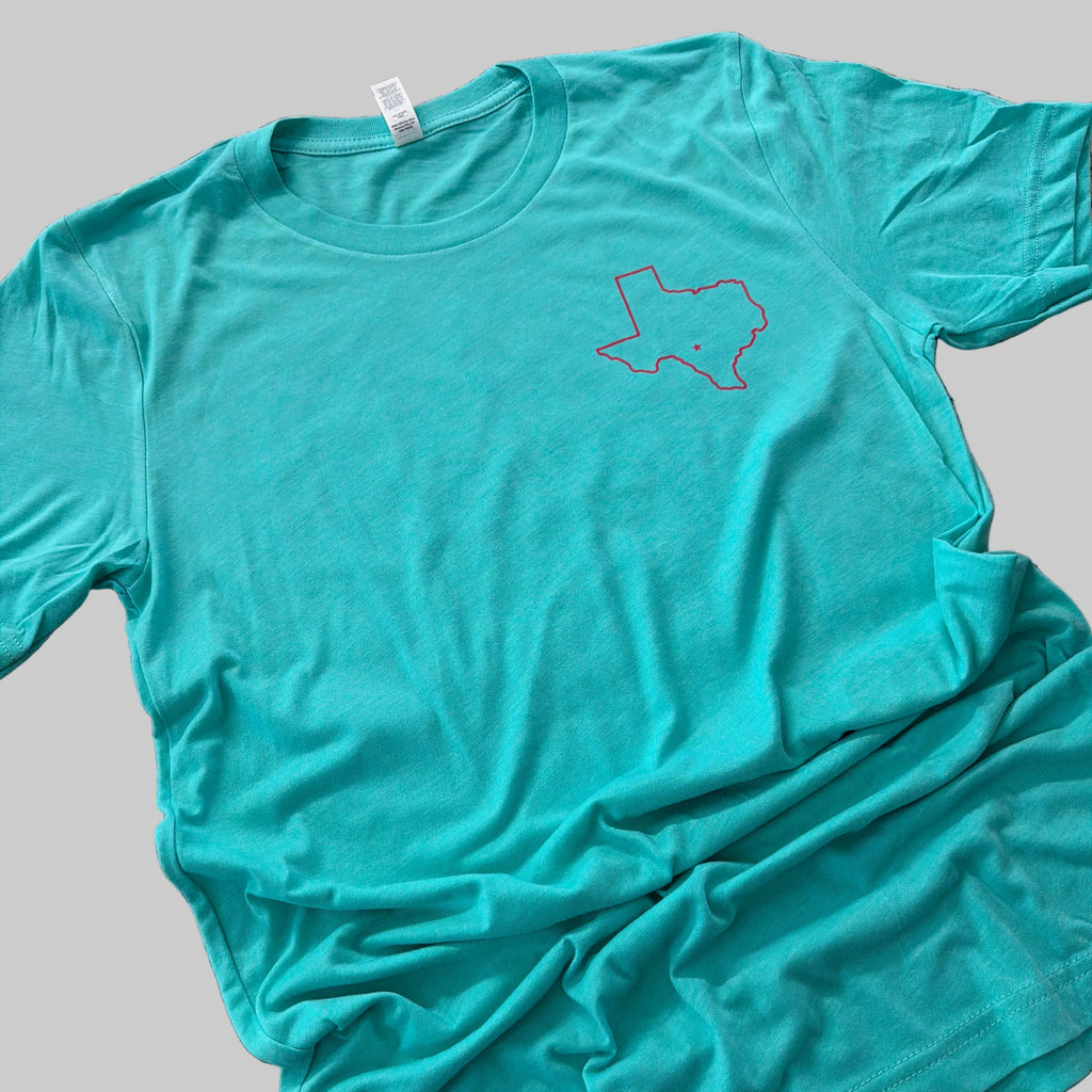 Teal t-shirt with a logo on a granite countertop