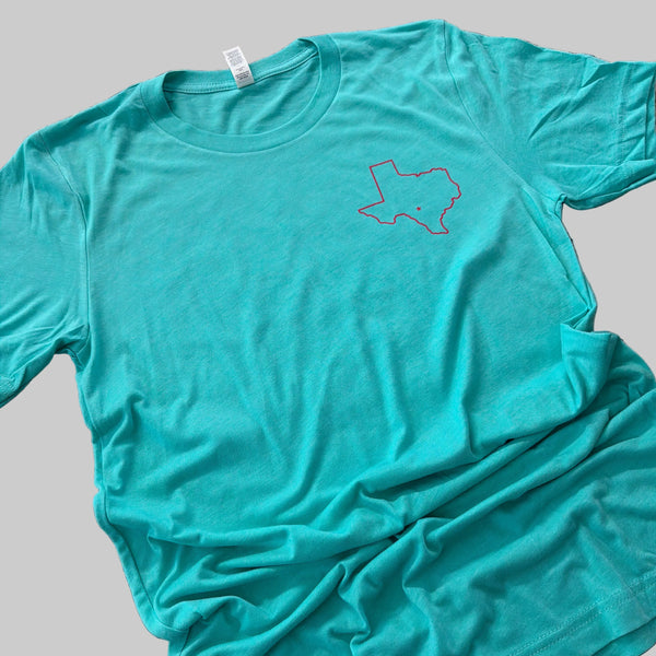 Teal t-shirt with a logo on a granite countertop