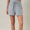 Light blue shorts worn by a person on a beige background
