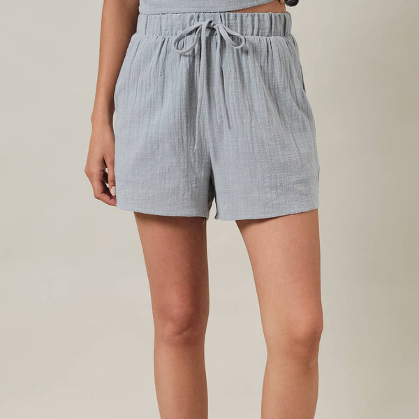 Light blue shorts worn by a person on a beige background