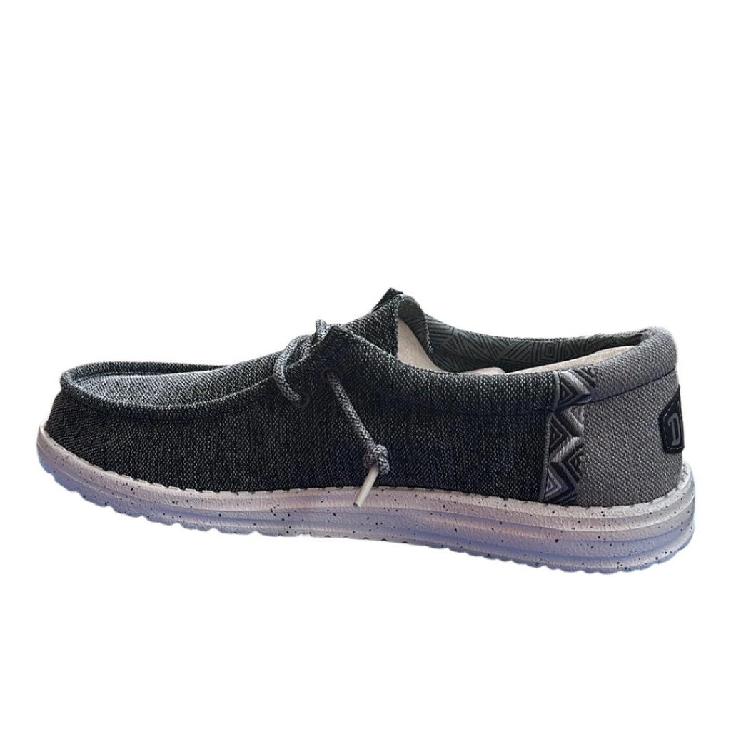 Black casual shoe with white sole on a white background
