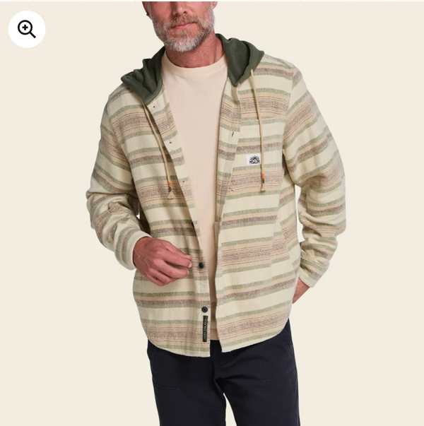 Man in a striped flannel hoodie on a cream background