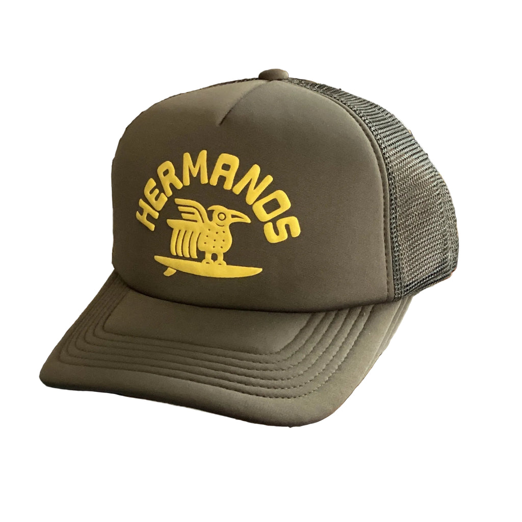 Green cap with yellow 'HERMANOS' logo on a white background