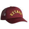 Maroon trucker cap with yellow text on a beige background