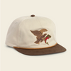 An off-white baseball cap with a brown flat brim and a brown button, featuring an embroidered brown bird holding a red and green fish on the front. The cap is photographed on a solid, light cream background.
