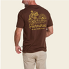 A man wearing a brown short-sleeve t-shirt from the back, featuring a large yellow graphic of a cowboy on a horse with the text 'Hermanos DE HOWLER'.