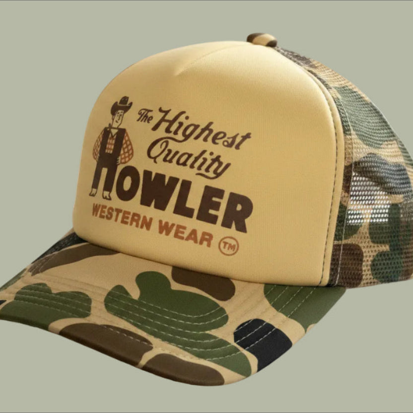 Camouflage and beige cap with 'Howler Western Wear' branding on a light gray background