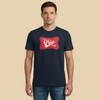 Man wearing a navy blue t-shirt with a red graphic and text on a beige background