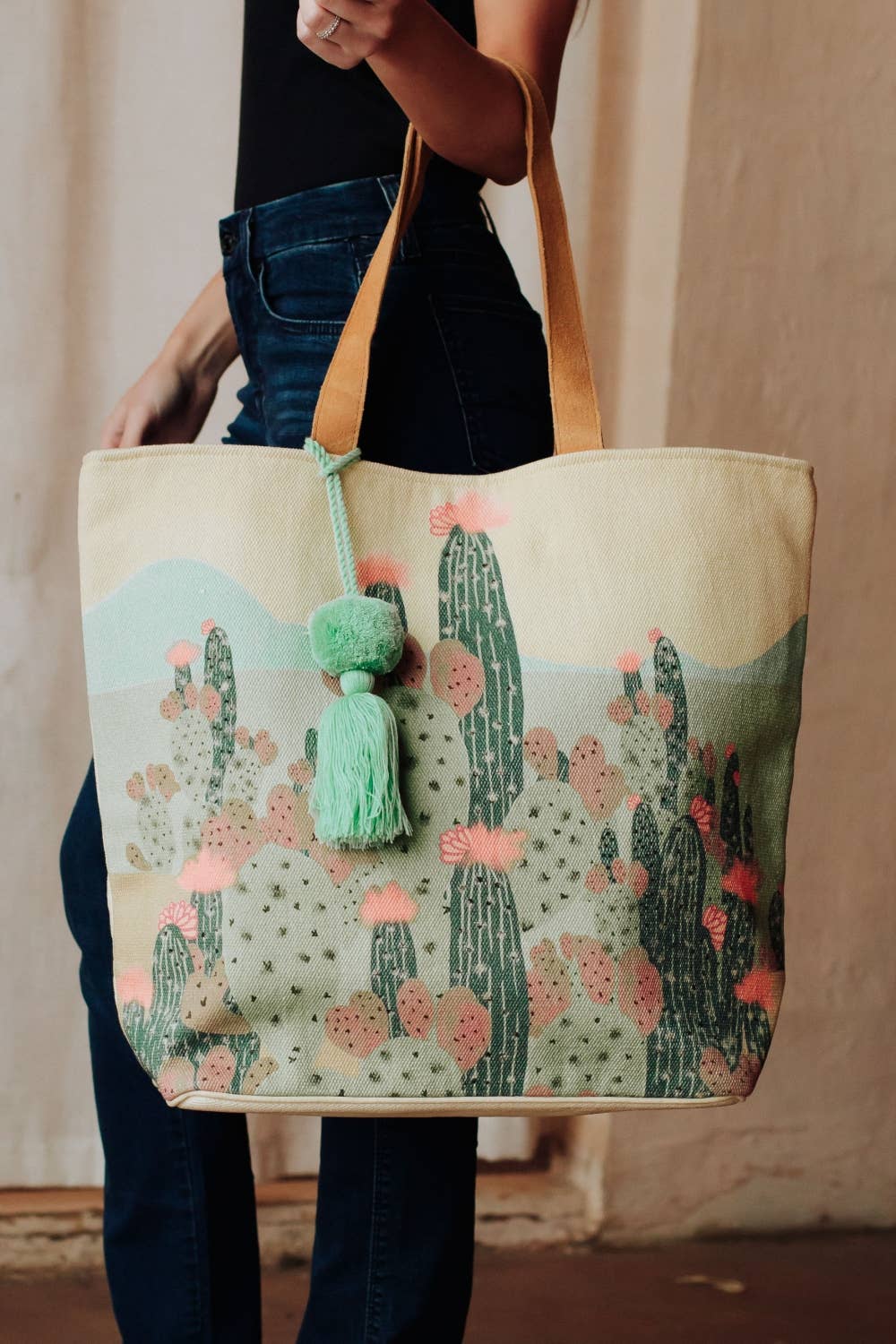 Tote bag with cactus design held by a person