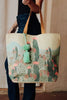 Tote bag with cactus design held by a person