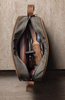 Open toiletry bag with grooming items against a textured wall