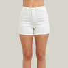 White denim shorts worn by a person on a plain background