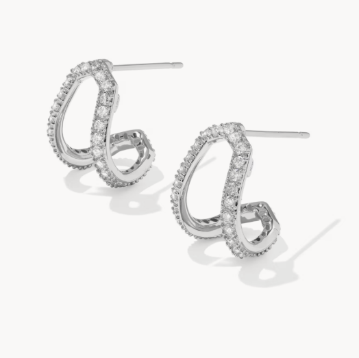 Pair of silver hoop earrings with clear gemstones on a white background