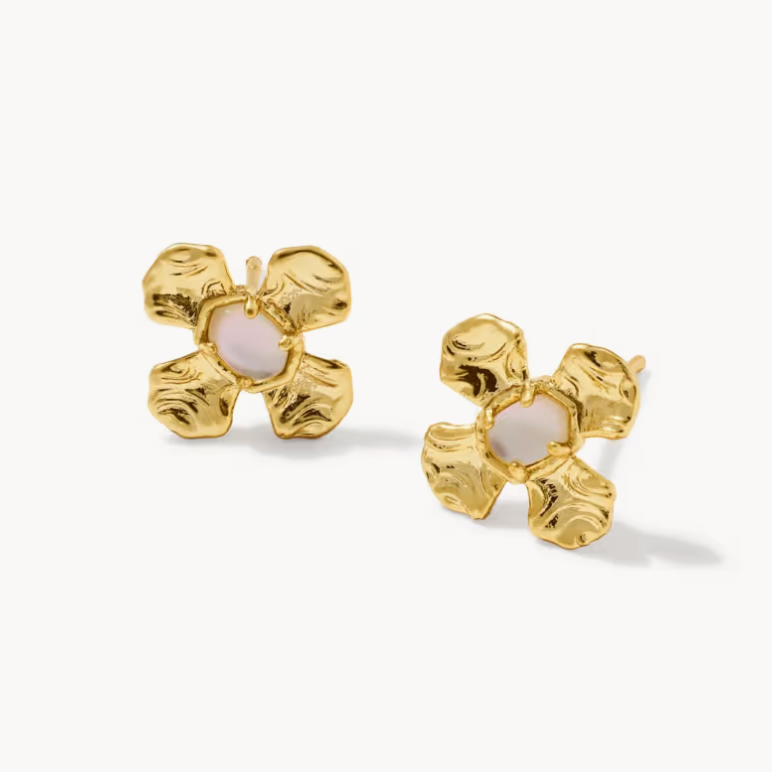 Gold flower earrings with a white center on a white background