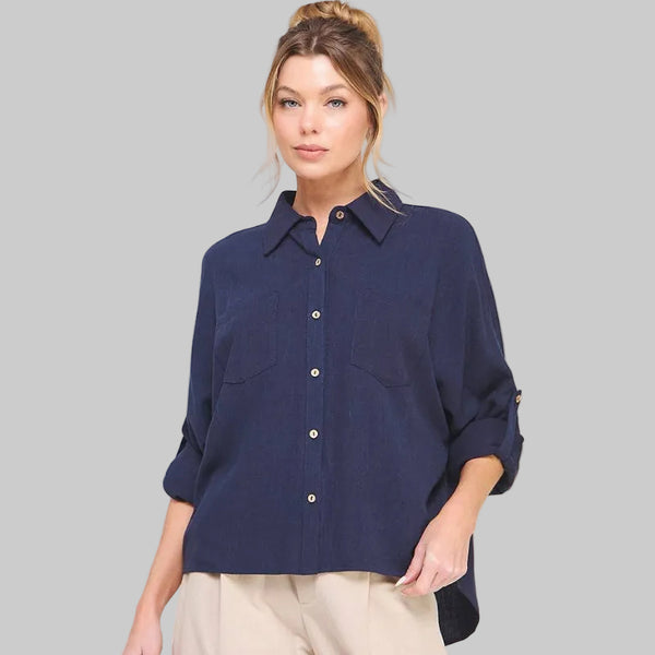 Woman wearing a navy blue shirt and beige pants on a white background