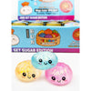 Three colorful bun-shaped squishies in front of a box labeled 'Rainbow Mystery' with a sugar edition theme.