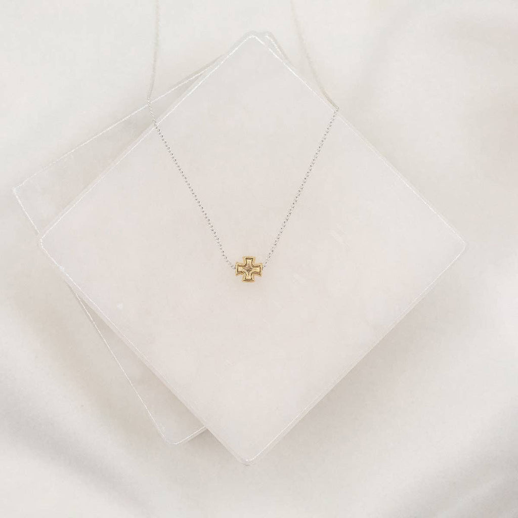 Gold necklace with a star-shaped pendant on a white surface
