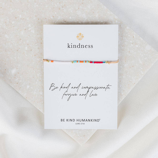 Bracelet on a 'kindness' card with 'Be Kind Humankind' text on a textured surface